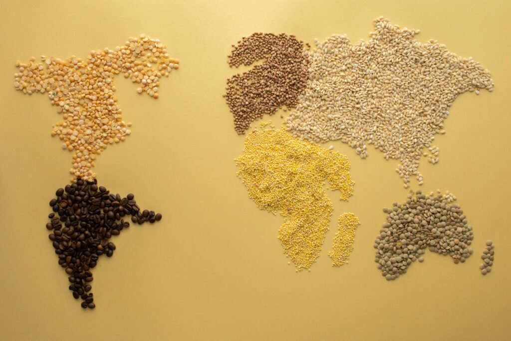 A world map creatively illustrated using diverse grains on a yellow background. Perfect for agricultural themes.